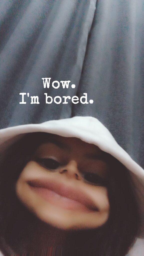 Girl in a white hoodie using a face distortion filter, with exaggerated lips and the text "Wow. I'm bored." over a dark curtain background.